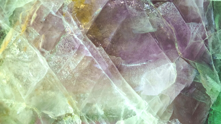 Texture of polished stone in green, white and purple colors.